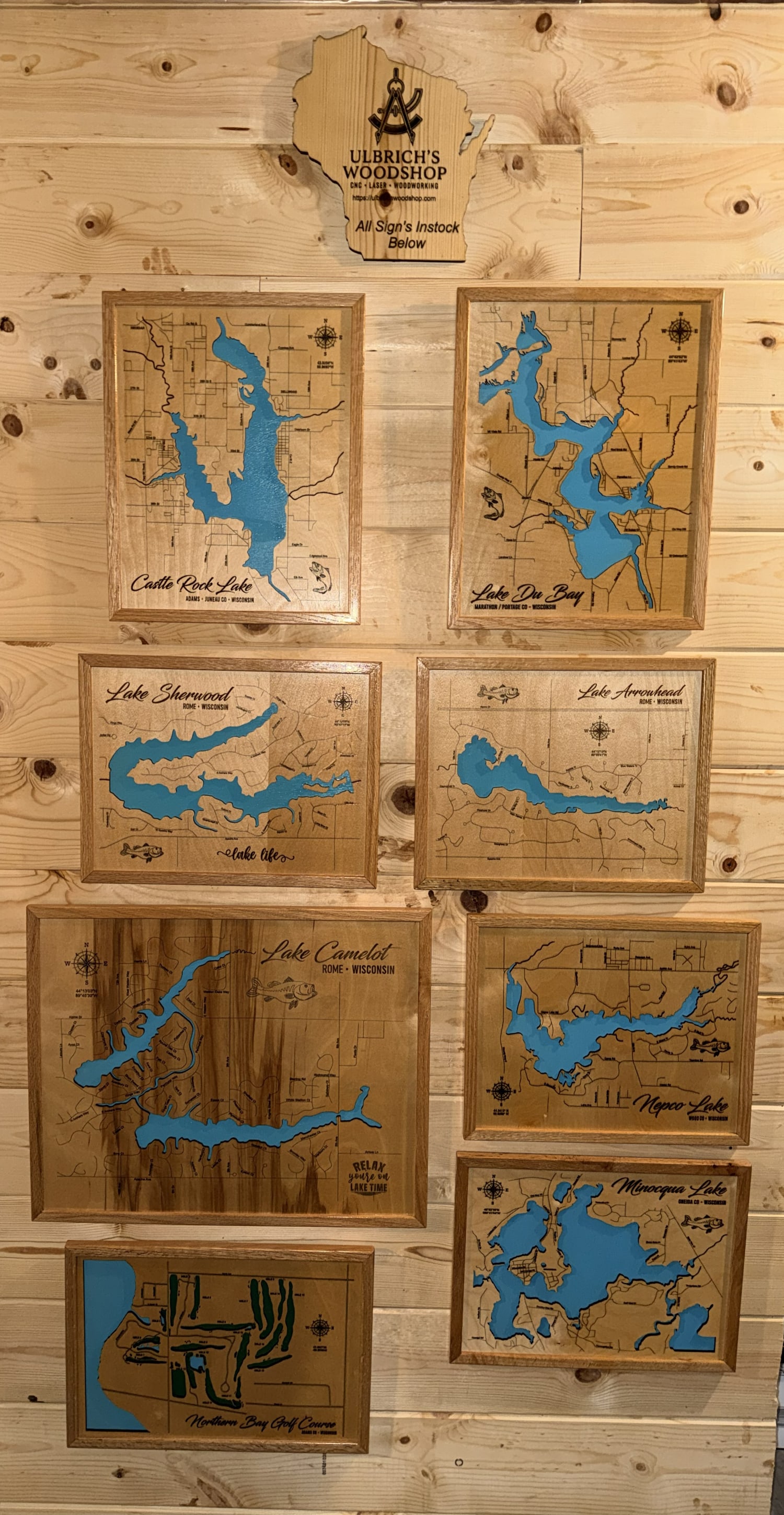 Real cabin wall with in-stock Ulbrich's Woodshop lake and golf signs